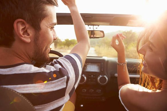 Happy young couple driving in a car