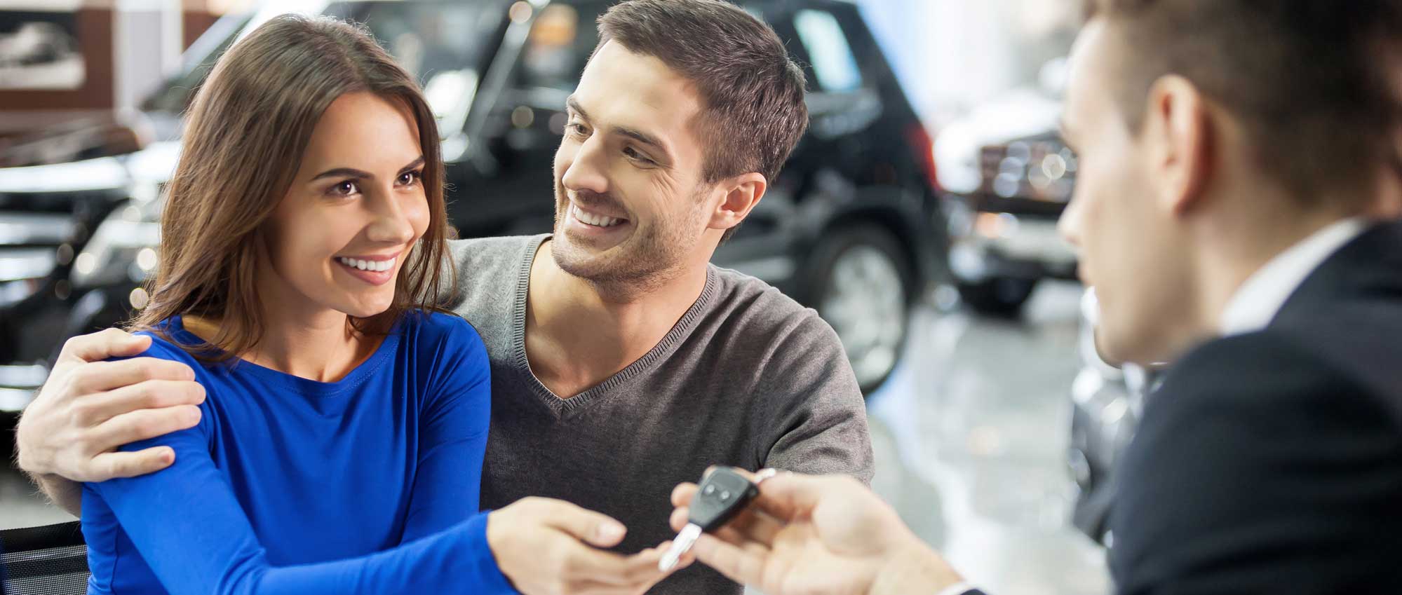 Happy couple being handed a set of car keys
